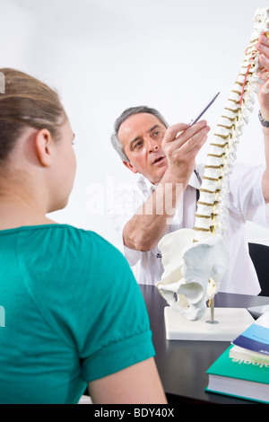 Arzt, einen jungen Patienten zu erklären, eine Wirbelsäule Stockfoto