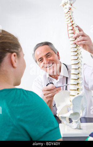 Arzt, einen jungen Patienten zu erklären, eine Wirbelsäule Stockfoto