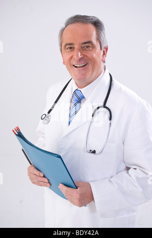 Lächelnde Arzt mit Stethoskop und medizinische Aufzeichnungen Stockfoto