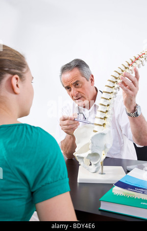 Arzt, einen jungen Patienten zu erklären, eine Wirbelsäule Stockfoto