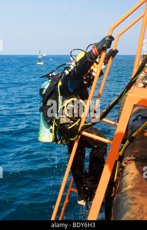 Gewerblicher Taucher aus dem Mittelmeer. Kabel von der Oberfläche liefern Strom für das Licht, Stockfoto