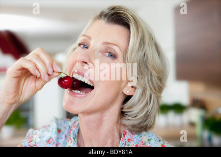 Ältere Frau Essen Kirschen Stockfoto