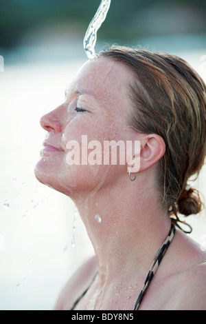 Frau unter Dusche lächelnd Stockfoto