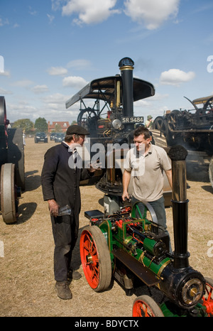 Zwei männliche Enthusiasten mit einem maßstabsgetreuen Modell Fahr motor in ein Land zeigen, in Essex. Stockfoto