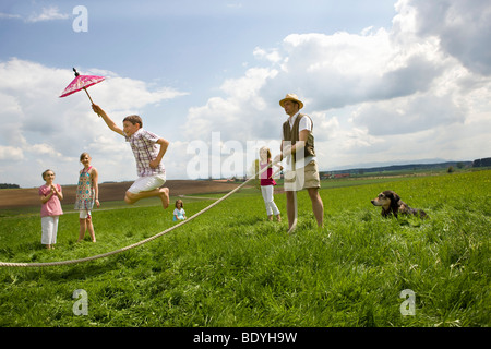 Glückliche Menschen zu springen, Abseilen in Landschaft Stockfoto