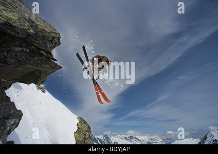 Skifahrer von einem Felsen springt. Stockfoto