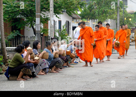 Kollektion Morning Almosen, Thakbat der Mönche und Novizen in den Klöstern von Luang Prabang, Männer und Frauen, die Verteilung von Lebensmitteln Stockfoto