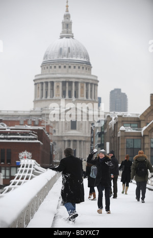 Menschen werfen Schneebälle auf die Millennium Bridge, London Stockfoto