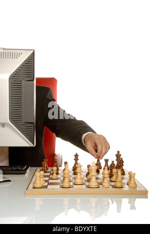 Business-Mann hinter einem Monitor spielen Schach, symbolisches Bild für Strategie Stockfoto