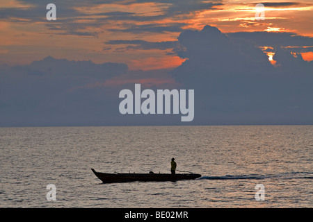 Silhouette von Fischer bei Sonnenuntergang. Fischer macht seinen Weg nach Hause bei Sonnenuntergang vor Bintan Island, Indonesien Stockfoto