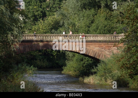 Menschen, die in der Sommersonne über die viktorianische Prince of Wales Bridge, Kelvingrove Park, Glasgow West End, Schottland, Großbritannien, wandern Stockfoto