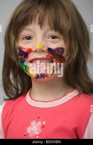 kleines Mädchen mit Gesicht mit Farbe befleckt Stockfoto