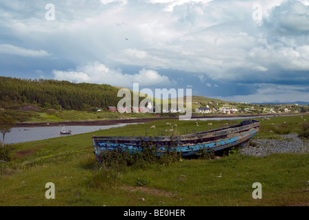 altes Ruderboot neben Loch Dunvegan auf der Isle Of Skye mit Dunvegan in den Hintergrund und die Sturmwolken sammeln Stockfoto