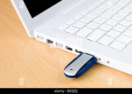Laptop und USB-Stick auf Holztisch angeordnet Stockfoto