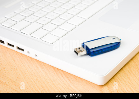 Laptop und USB-Stick auf Holztisch angeordnet Stockfoto