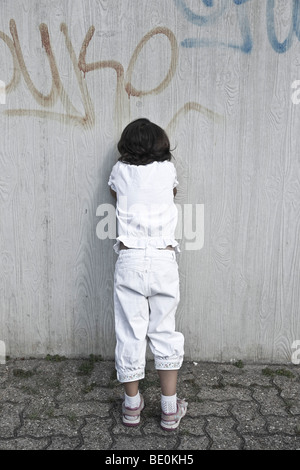 Junges Mädchen an eine Wand gelehnt, Weinen Stockfoto