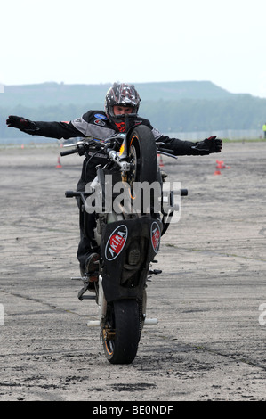 Streetbike Freestyle Stunt Fahrer zeigen in Warschau, Polen. Mann, balancieren auf Hinterrad mit ausgebreitet Hände Stockfoto