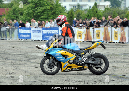 Streetbike Freestyle Stunt Fahrer zeigen in Warschau, Polen. Mann reitet auf seinem Motorrad sitzend auf Tank und Lenker Stockfoto