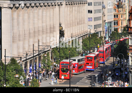 Oxford Street-Fassade des Kaufhauses Selfridges mit langen Schlange Doppel Decker roten Londoner Busse an Bushaltestellen & Kreuzungen Stockfoto