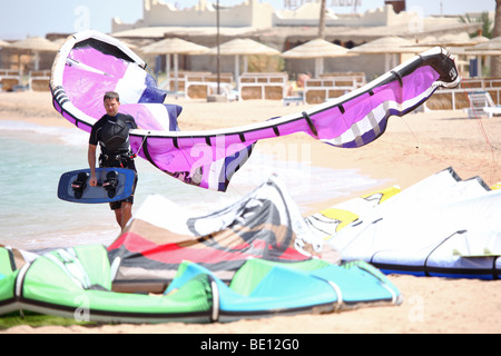 Zu Fuß am Strand mit seinem Kite Kiteboarder. Stockfoto