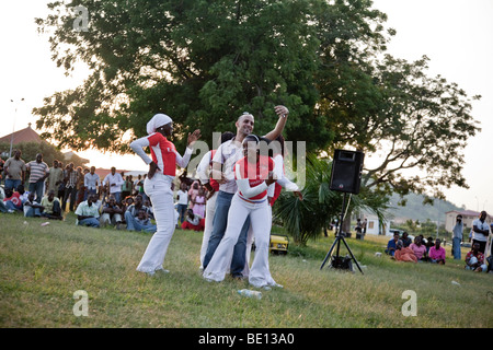 Eine Gruppe von Tänzern in einem Park in Abuja, Nigeria einen Mann umgeben und mit ihm zu tanzen beginnen. Stockfoto