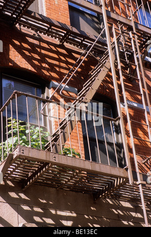 Feuerleiter New York City. Rotes Ziegelgebäude mit einer Fabrik an der Feuertreppe. Lower Manhattan USA Stockfoto