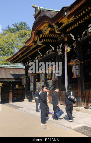 Studenten in uniform betend vor einem Shinto-Schrein, Kintano Schrein, Kyoto, Japan, Südostasien, Asien Stockfoto