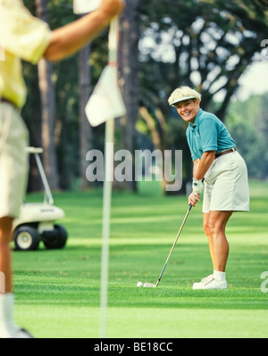 Ältere Frau Golfer setzen auf grün Stockfoto