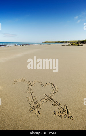 Herz mit einem Pfeil durch das ziehen an einem Sandstrand in Wales Stockfoto
