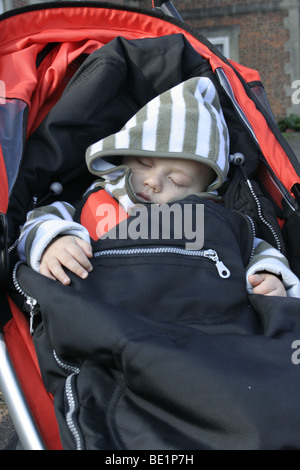 Kleiner Junge schlafend in seinem buggy Stockfoto