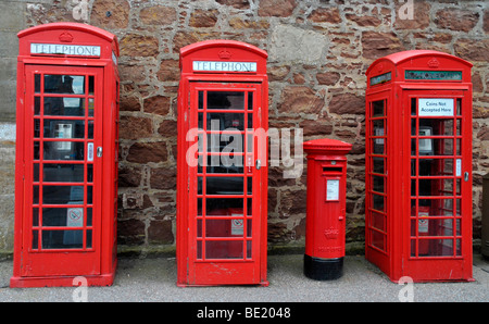 Drei alte rote Telefonzellen und einen roten Briefkasten. Stockfoto