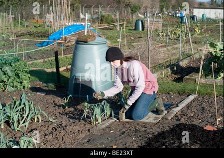 Junge Frau Prüfung Winter Porree & Gemüse auf Zuteilung Kent UK Stockfoto