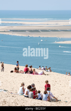 Leute sitzen auf den Sand auf der Dune du Pilat mit Blick auf den Atlantischen Ozean; Dune du Pilat, Aquitaine, Frankreich Stockfoto