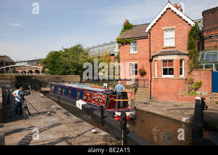 Manchester, England, Vereinigtes Königreich. Mann filmt Narrowboat in Dukes Lock auf Rochdale Kanal in Castlefield Urban Heritage Park Stockfoto