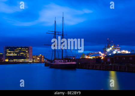 Schottland, Edinburgh, Leith. Boot vor Anker im Hafen von Leith mit dem Einkaufszentrum Ocean Terminal am Hafen von Leith. Stockfoto