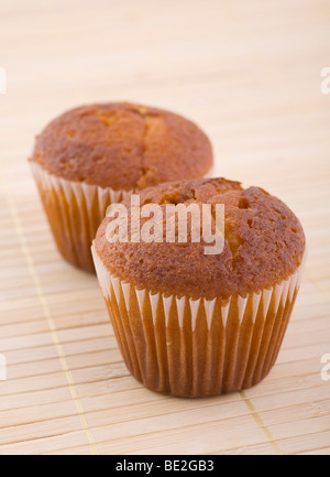 Zwei Muffins auf Bambusmatte, Nahaufnahme, Studio gedreht. Stockfoto