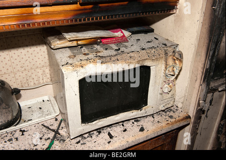 Geschmolzene Mikrowelle nach Küchenfeuer im Haus Stockfoto
