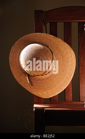 Strohhut und Stuhl. Stockfoto