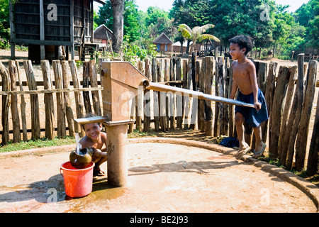 Kinder, die Wasserpumpe, Kreung Bergvolk Dorf in der Nähe von Banlung, Provinz Ratanakiri, Kambodscha in Betrieb Stockfoto