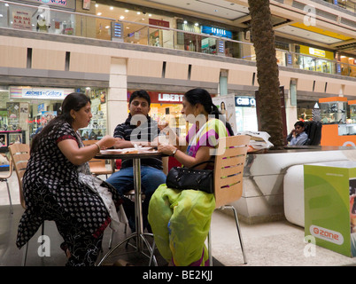 Inder genießen Sie einen Snack in einem Café in der Iscon Mall / Einkaufszentrum in Surat, Gujarat. Indien. Stockfoto