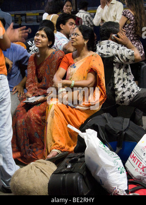 Frauen-Passagiere sitzen auf Gepäck während des Wartens auf einen Zug auf der Plattform. Bahnhof Surat, Gujarat. Indien. Stockfoto