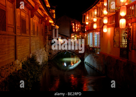 Alte Holzhäuser und roten Laternen, Kanal, Brücke, Altstadt von Lijiang, UNESCO-Weltkulturerbe, Nachtszene, Yunnan Stockfoto