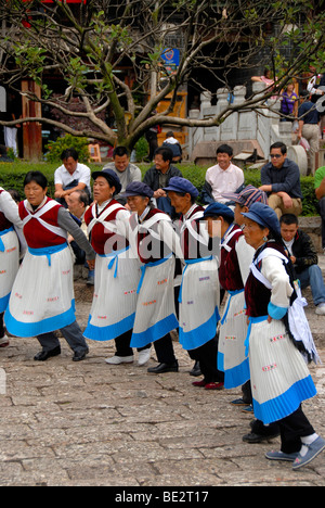 Tanz der Marktfrauen, Ethologie, Frauen von der ethnischen Gruppe der Naxi Tanz in traditionellen Kostümen auf dem alten Marktplatz, UN Stockfoto