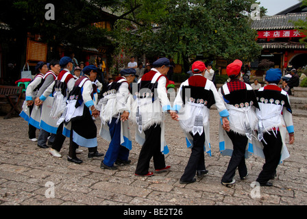 Tanz der Marktfrauen, Anthropologie, Frauen der ethnischen Gruppe der Naxi in traditioneller Tracht auf dem alten Marktplatz, Halloween, h Stockfoto