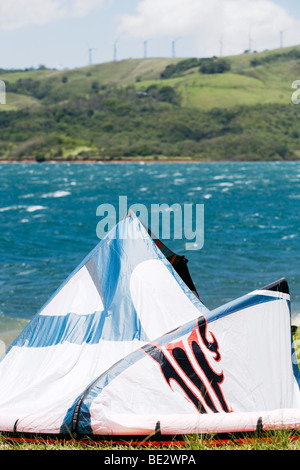 Ein Kitesurfer startet seine Ausrüstung auf See Arenal mit Wind Erzeugung von Maschinen auf dem Hügel hinter Stockfoto