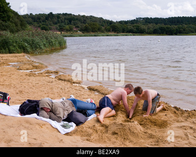 Jungen spielen am Strand durch das Wasser am großen Teich Frensham. Churt, in der Nähe von Farnham, Surrey. VEREINIGTES KÖNIGREICH. Stockfoto