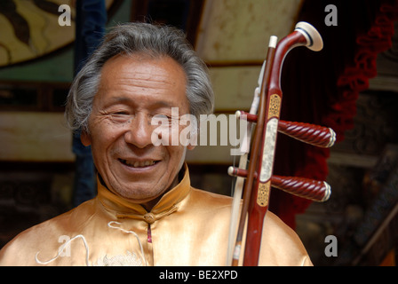 Porträt, Lächeln Naxi Musiker, Halloween, Mann mit Saiteninstrument, UNESCO-Weltkulturerbe, Lijiang, Provinz Yunnan, Peopl Stockfoto