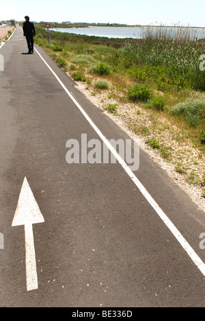 Mann im dunklen Anzug Spaziergänge entfernt sich Küstenweg mit weißer Pfeil auf sie gekleidet Stockfoto