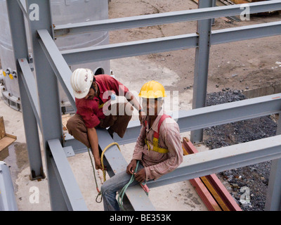 Indische Bauarbeiter Montage eines Fabrikgebäudes in einem Industriegebiet von Indien, in Surat, Gujarat. Indien. Stockfoto