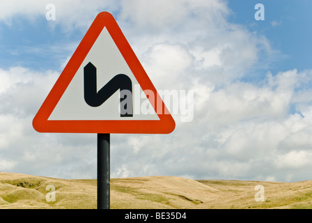 Doppelte Biegung Straßenschild gegen blauen Himmel mit weißen Wolken an Lancashire/Yorkshire Grenze Stockfoto